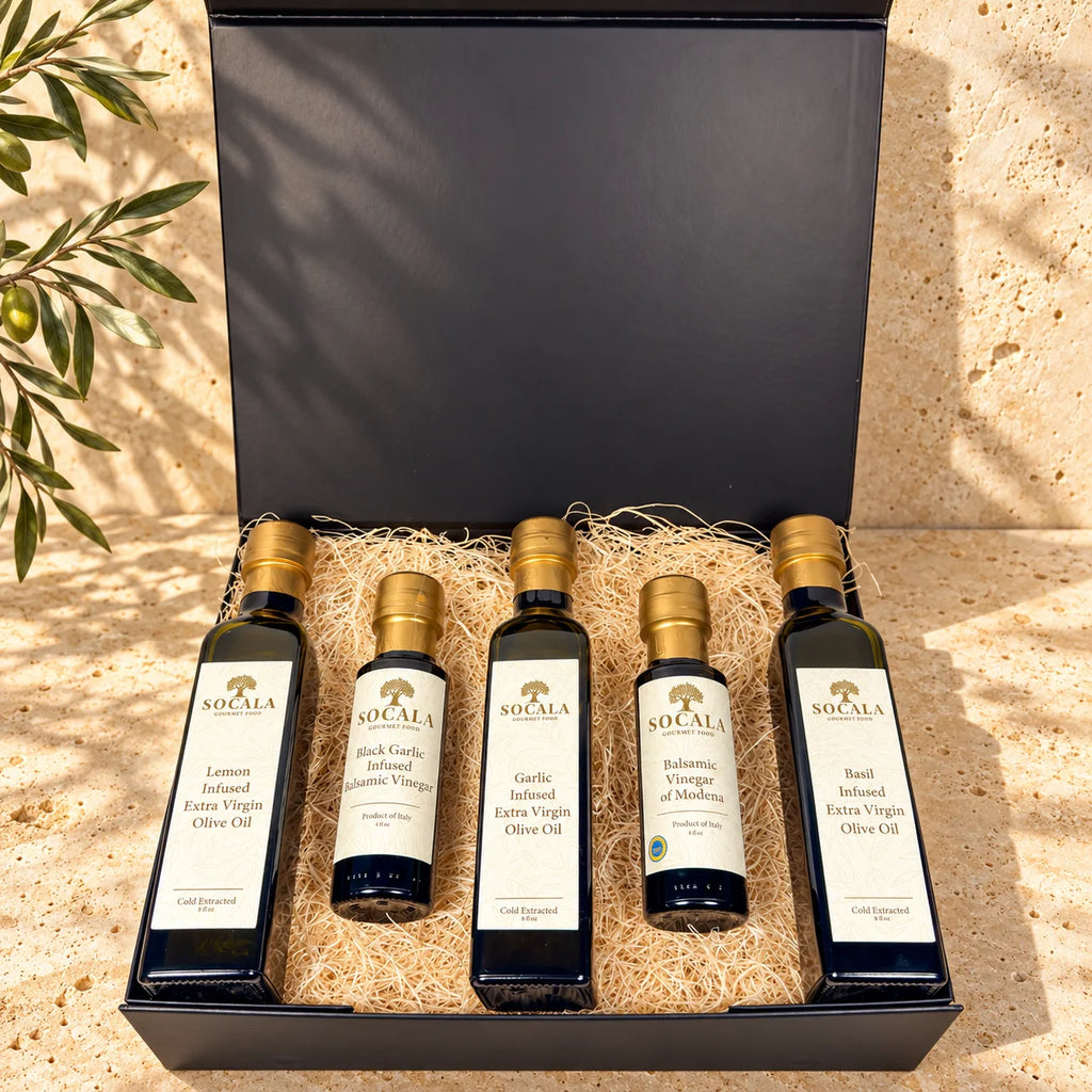 SOCALA five-bottle gift set with lemon, garlic and basil infused olive oils and two balsamic vinegars in an open black box.