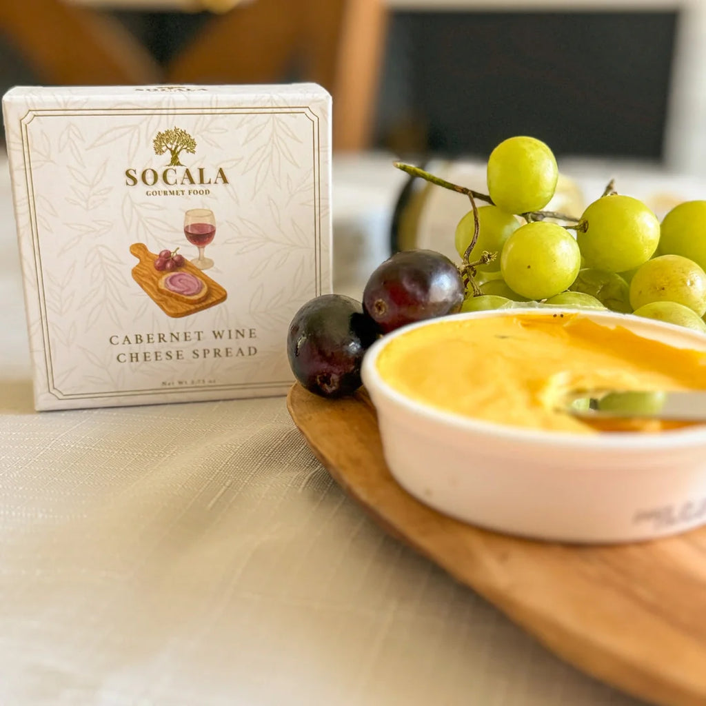 Socala Cabernet Wine Cheese Spread with grapes on a wooden board