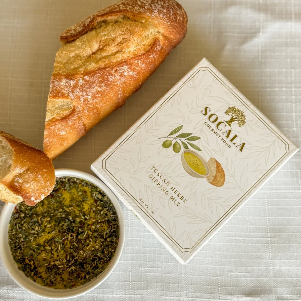 Box of Socala Tuscan Herb Dipping Mix with bread and herbs on a textured surface